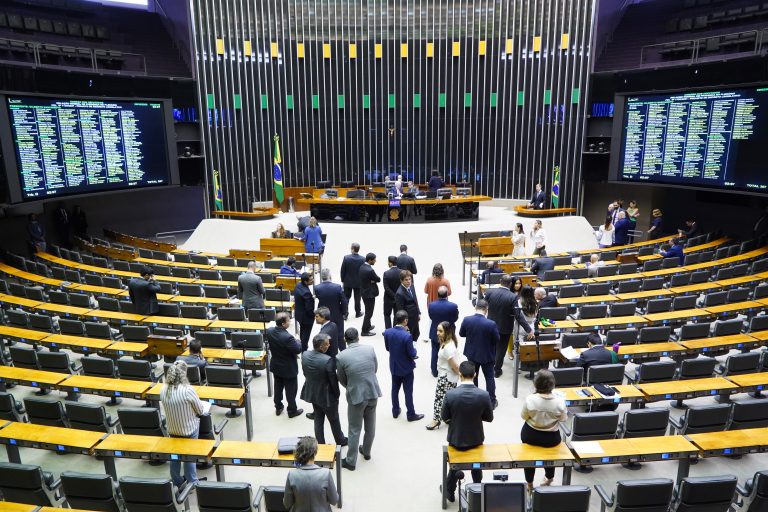 Deputados em pé no Plenário da Câmara estão conversando