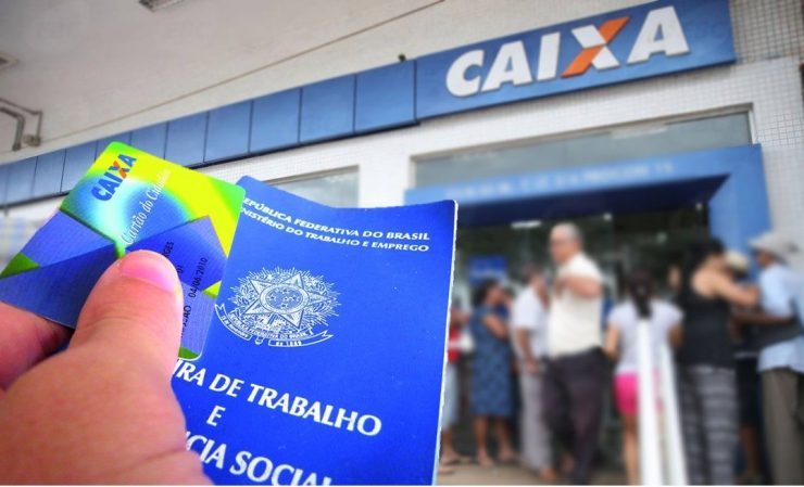 Foto de uma carteira trabalho, ao fundo a fachada da Caixa Econômica