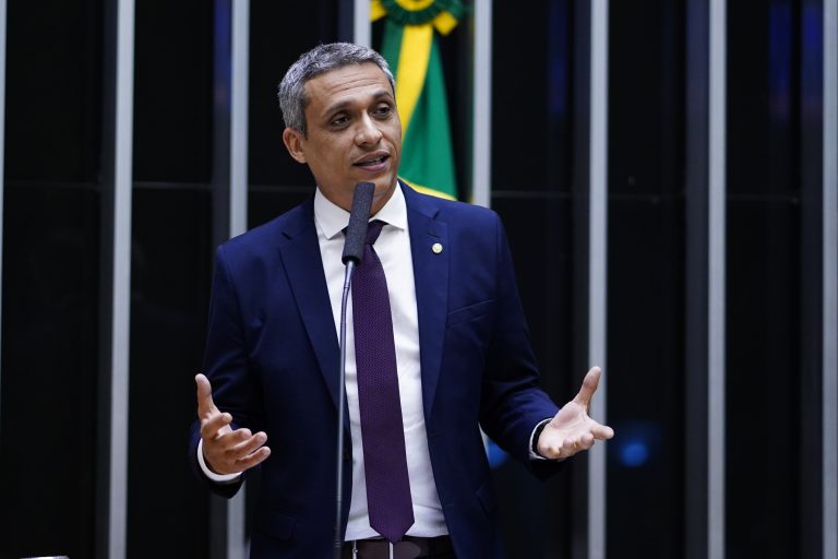 Deputado Gustavo Gayer fala ao microfone. Ele é um homem branco, tem o cabelo grisalho, usa terno azul-marinho e camisa branca