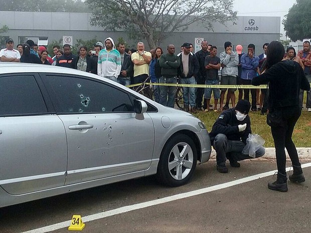 Perito recolhe cápsulas de munição junto a carro de acusado de tentativa de homicídio morto pouco antes de julgamento no Fórum de Santa Maria na manhã desta quinta (28) (Foto: Fernando Caixeta/G1)