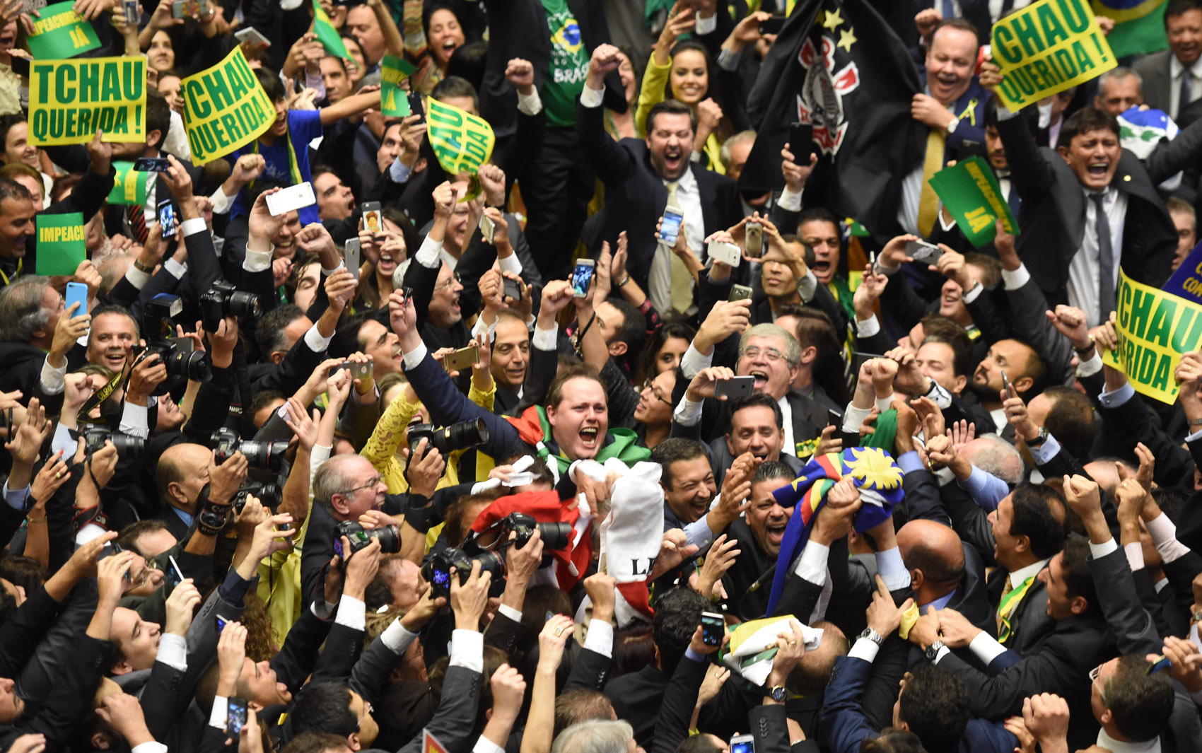 Brazil's lawmakers celebrate after they reached the votes needed to authorize President Dilma Rousseff's impeachment to go ahead, at the Congress in Brasilia on April 17, 2016. Brazilian lawmakers on Sunday reached the two thirds majority necessary to authorize impeachment proceedings against President Dilma Rousseff. The lower house vote sends Rousseff's case to the Senate, which can vote to open a trial. A two thirds majority in the upper house would eject her from office. Rousseff, whose approval rating has plunged to a dismal 10 percent, faces charges of embellishing public accounts to mask the budget deficit during her 2014 reelection. / AFP PHOTO / EVARISTO SA
