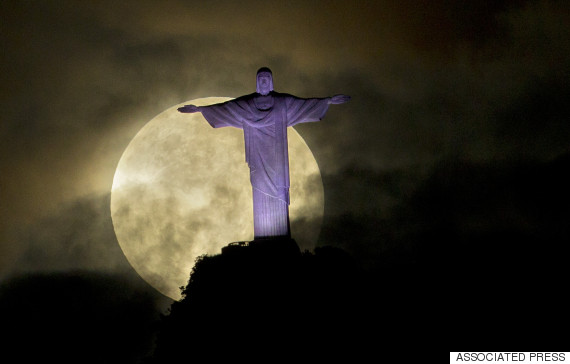 A "supermoon" is seen behind the Christ the Redeemer statue in Rio de Janeiro, Sunday, May 6, 2012. A supermoon is the coincidence of a full moon (or a new moon) with the closest approach the moon makes to the Earth. (AP Photo/Victor R. Caivano)