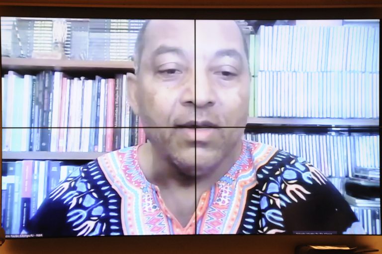 Homem participa de videoconferência. Ele fala olhando para a tela do computador