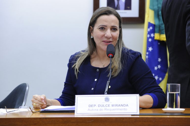 Deputada Dulce Miranda está sentada falando ao microfone