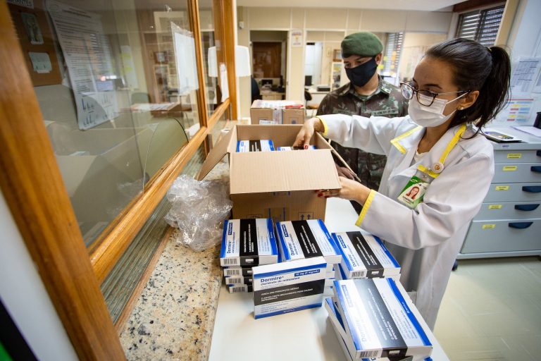 Soldado entrega a profissional de saúde medicamentos para intubação