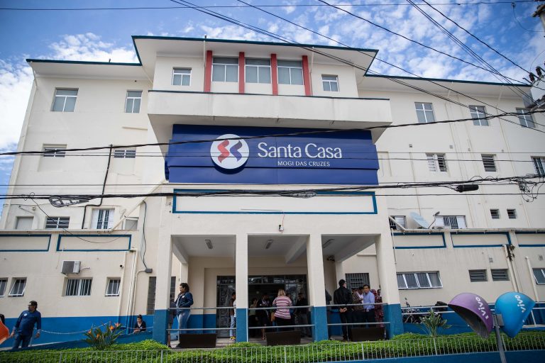 Fachada de um prédio branco de três andares com um letreiro azul escrito "Santa Casa"