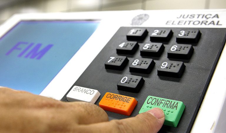 Pessoa votando em urna eletrônica
