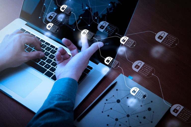 Um laptop com vários ícones de cadeados e uma pessoa com o indicador num desses ícones