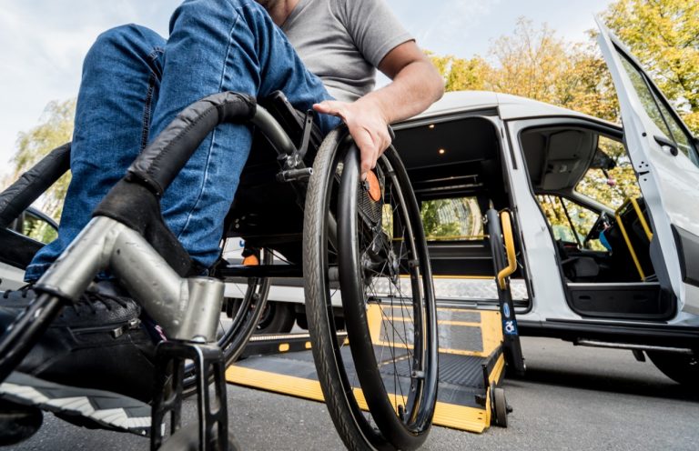 Uma pessoa em cadeira de rodas embarca um carro adaptado