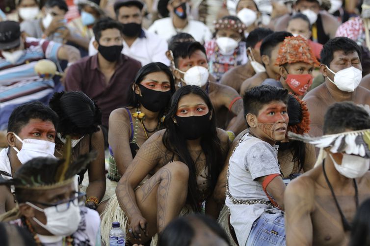 Indígenas acompanham sessão em um telão montado em frente ao Supremo Tribunal Federal (STF), na Praça dos Três Poderes