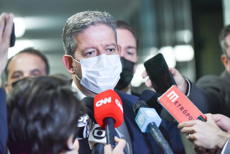 Deputado Arthur Lira concede entrevista. Ele usa máscara e há vários microfones à frente dele