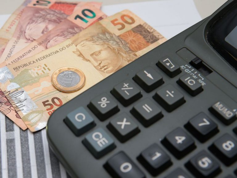 Foto de uma calculadora e notas de dinheiro