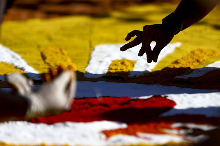 Fiéis confeccionam os tradicionais tapetes de serragem durante a Festa de Corpus Christi de Brasília, que retorna à Esplanada dos Ministérios após 2 anos de celebrações reduzidas por conta da pandemia.