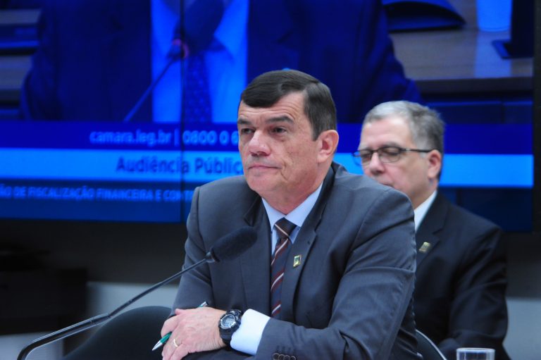 Ministro Paulo Sérgio Nogueira de Oliveira fala ao microfone. Ele é um homem branco, com cabelo escuro e usa terno cinza