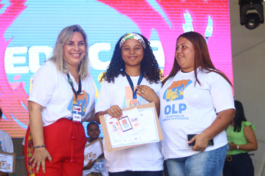 Mayra Vitória de 13 anos, ao centro, recebendo o certificado ao vencer a categoria memórias literárias. Foto: Pedro Farias/Ascom Semed