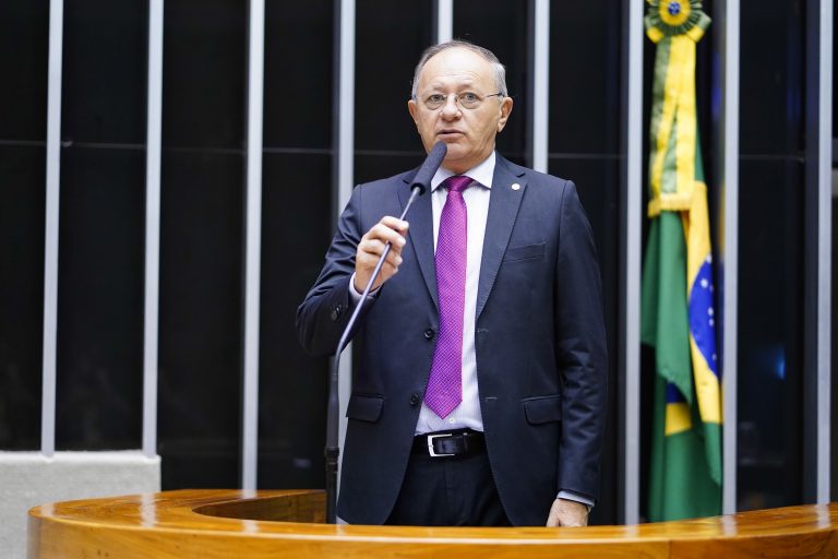 Deputado Benes Leocádio fala ao microfone. Ele é branco, tem cabelo branco e usa terno azul marinho