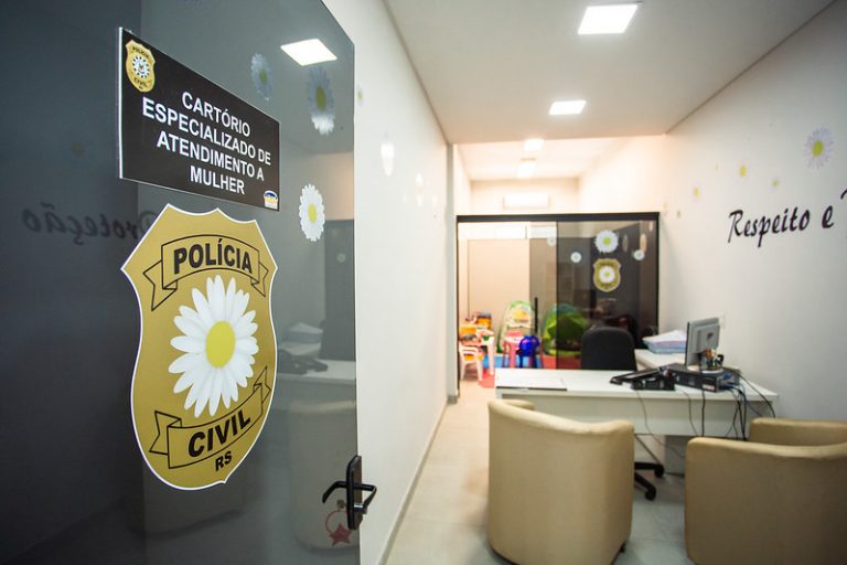 Sala em delegacia com uma mesa e duas cadeiras. Ao fundo há uma brinquedoteca