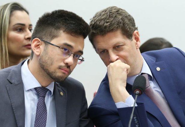 Ricardo Salles (D), relator, conversa com Kim Kataguiri durante a reunião da CPI